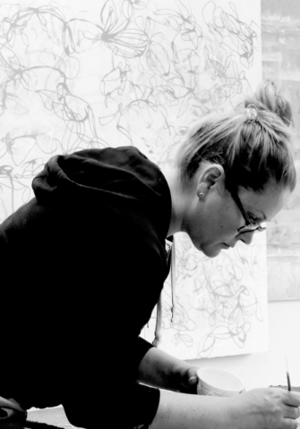 Contemporary abstract fine artist Sara Richardson working on a nature inspired painting in her art studio