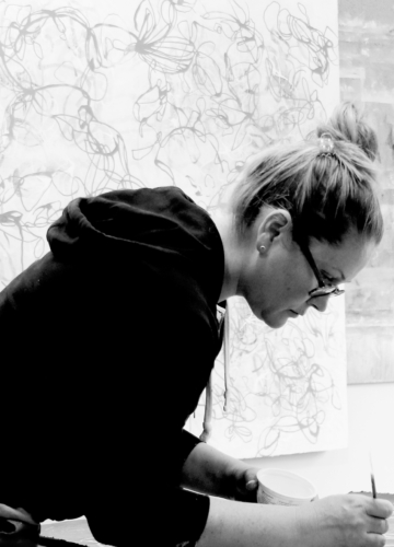 Contemporary abstract fine artist Sara Richardson working on a nature inspired painting in her art studio