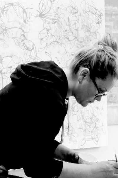 Contemporary abstract fine artist Sara Richardson working on a nature inspired painting in her art studio